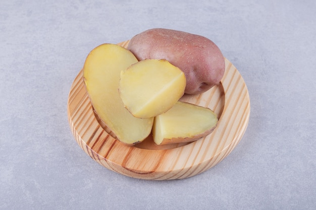 Boiled delicious potatoes on wooden plate. 