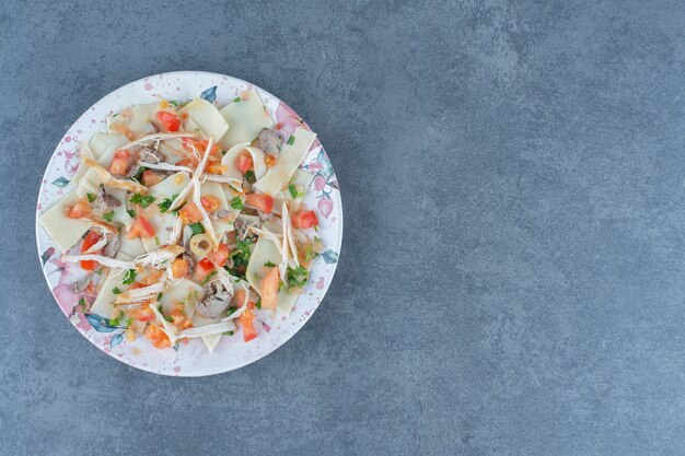 カラフルなプレートに刻んだ野菜と一緒に茹でた生地。