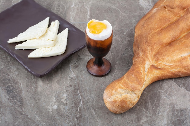 Boiled egg with fresh white bread on marble background. High quality photo