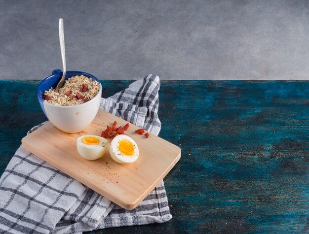 Boiled egg with oatmeal on wooden board