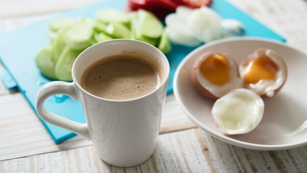 ゆで卵、新鮮なキュウリのサラダとコーヒーカップの朝食セット - トップビュー朝食食品のコンセプト