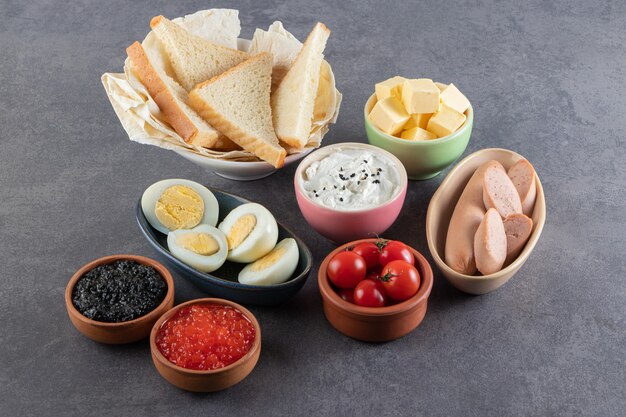 Boiled eggs with red and black caviar placed on a stone table . 