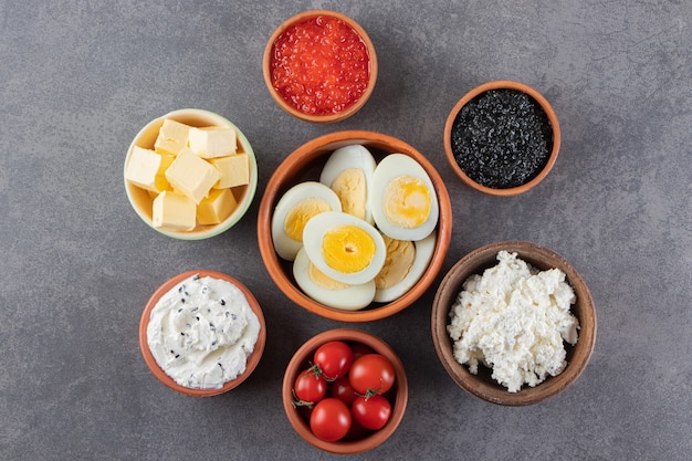 Boiled eggs with red and black caviar placed on stone . 