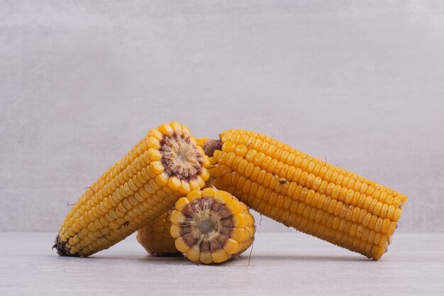 Free photo boiled half cut corns on white table.