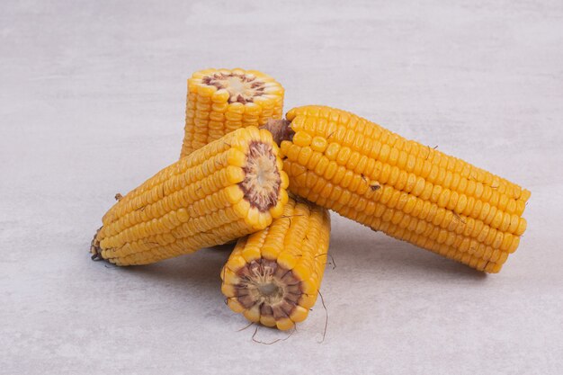 Boiled half cut corns on white table.