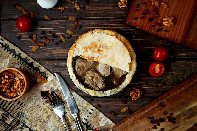 Boiled meat in clay pots covered with bread