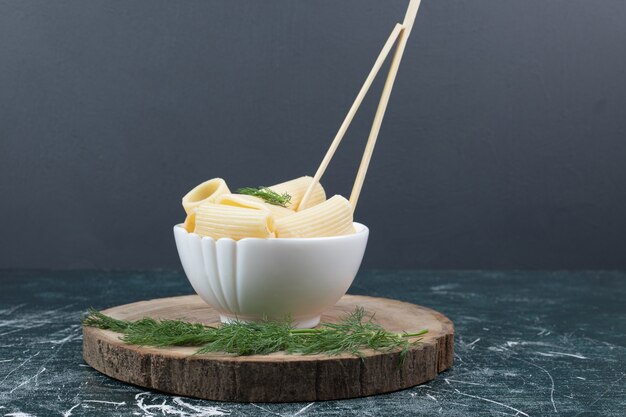Boiled pasta in white bowl with chopsticks and coriander. High quality photo