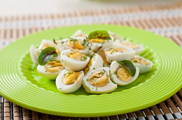 Free photo boiled quail eggs halves on a green plate