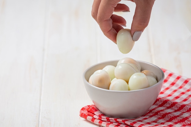 Boiled quail eggs on the white wooden surface.