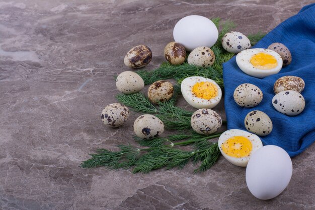 Boiled and raw eggs on piece of blue tissue .