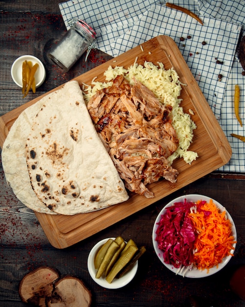 Boiled rice with pieces of chicken on a wooden board