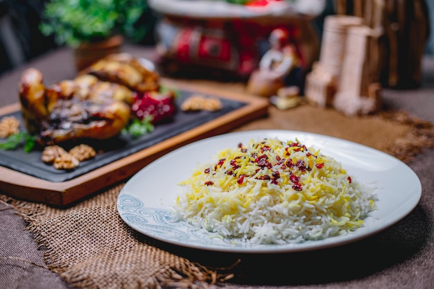 Foto gratuita riso bollito con spezie su un piatto bianco sul tavolo