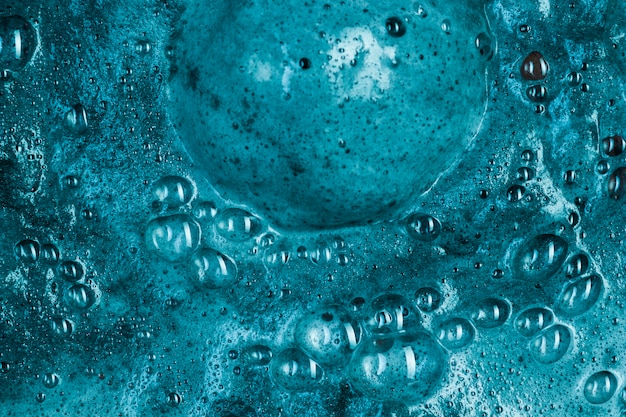 Boiling blue liquid with foam and big blob