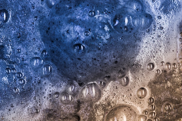 Бесплатное фото Кипящая темная жидкость с аквамариновой пеной и большой капли