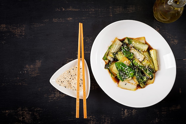 Bok choy vegetables stir fry with soy sauce and sesame seeds. Chinese cuisine. Top view