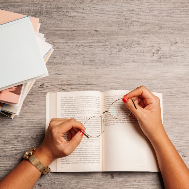 Foto gratuita concetto di libri con le mani che tengono gli occhiali