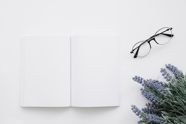 Free photo book cover mockup with glasses and flower decoration