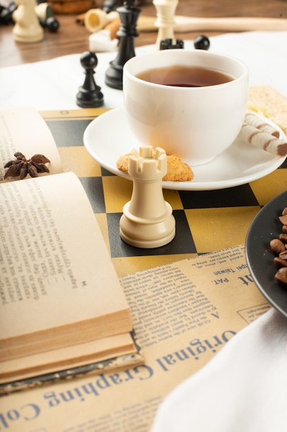 A book,a cup of tea and a chess rook