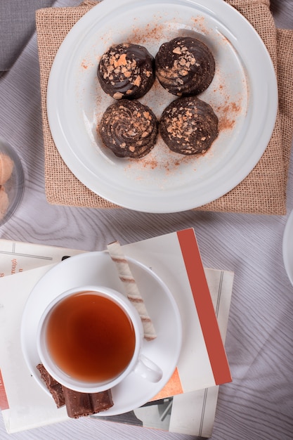 Book,cup of tea and chocolate on the table