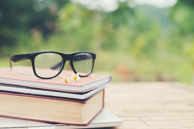 Book and eye glasses for read and write over blurred nature outd