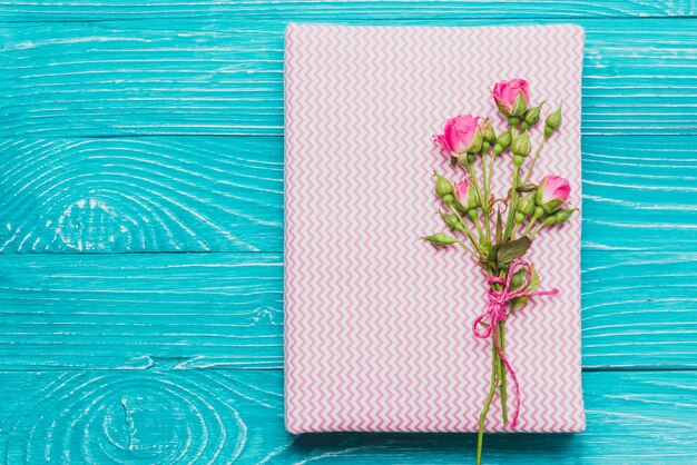 Book and flowers on wooden surface