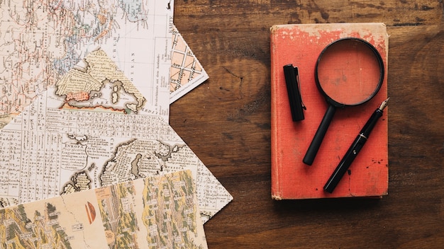 Free photo book and magnifying glass near maps