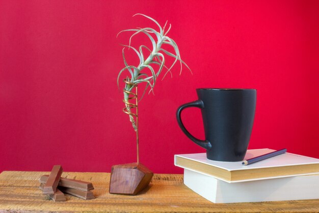 紅茶、チョコレート棺と木製の背景に植物のカップで予約