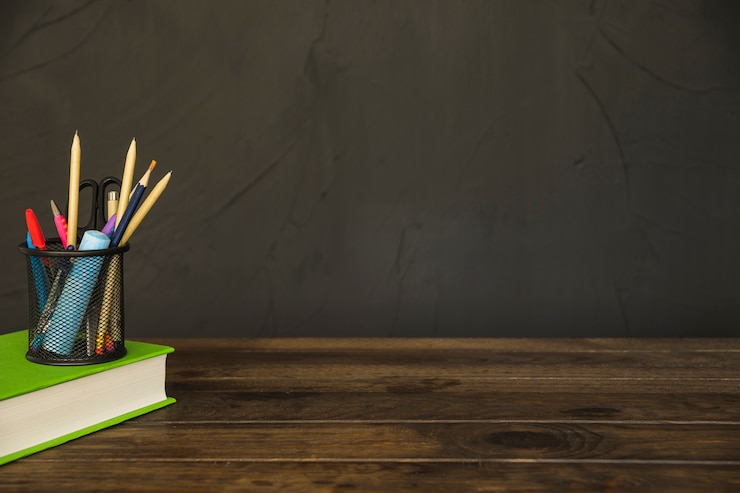 Free Photo book with pencil cup with stationery on desk