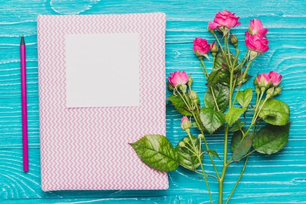 無料写真 book with piece of paper and decorative flowers