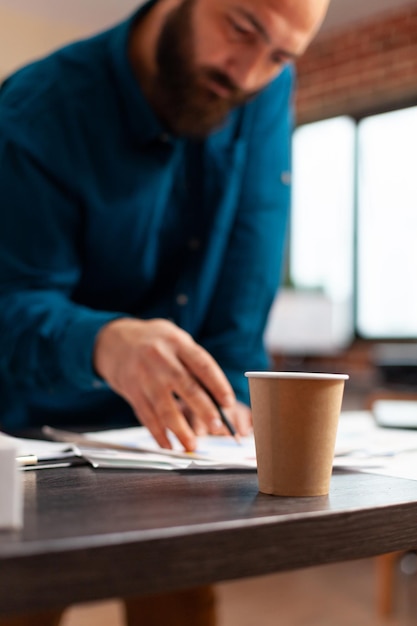 Bookkeeper man planning company meeting analyzing marketing strategy papers working at investment presentation in startup office. businessman looking at financial documents. business concept