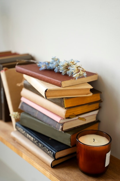 Бесплатное фото Расположение книг на полке с цветком под высоким углом