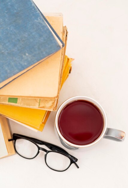 Books arrangement with glasses and cup