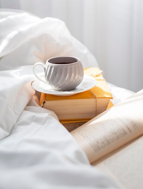 Books in bed with cup