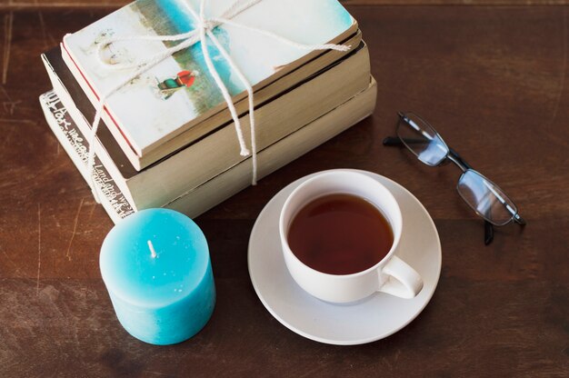 Books, blue candle, coffee and glasses