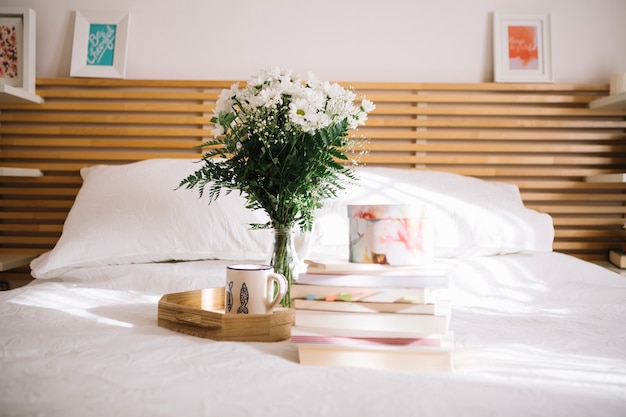 Books and box near tray with bouquet