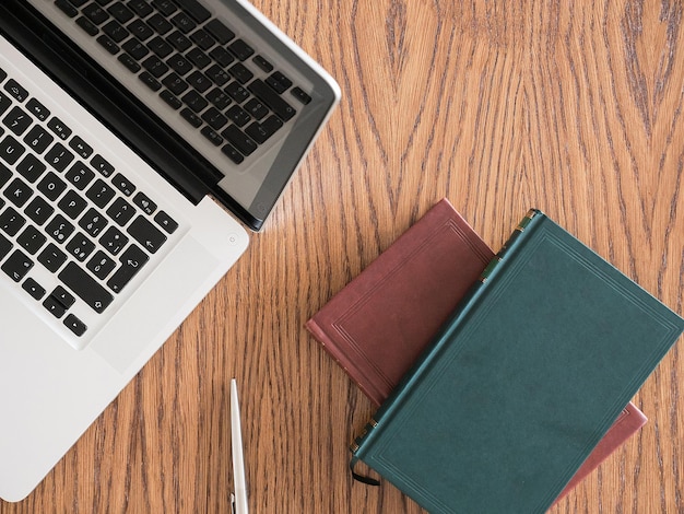 Books, headphones and laptop on a table. Top view