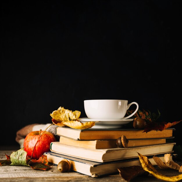 Books and leaves on black background