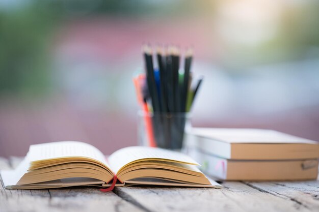 Books pencils on a wooden table on a blurred background