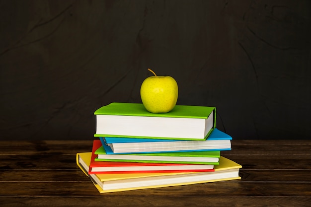 Books pile with apple on top