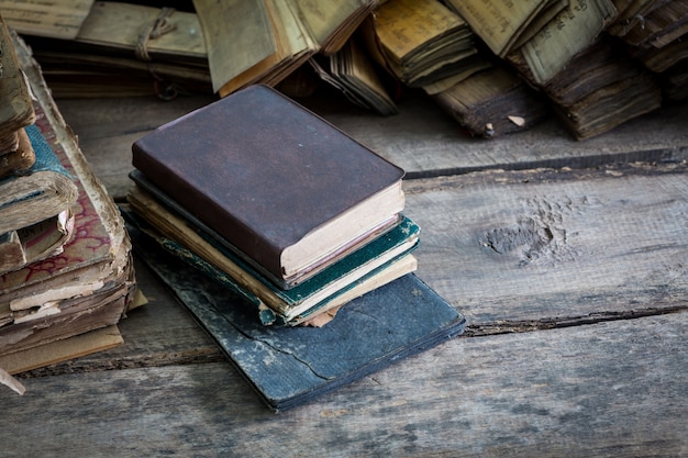 Books piled up on a wooden floor