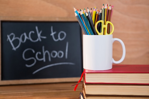 Books stack with colored pencil on a mug