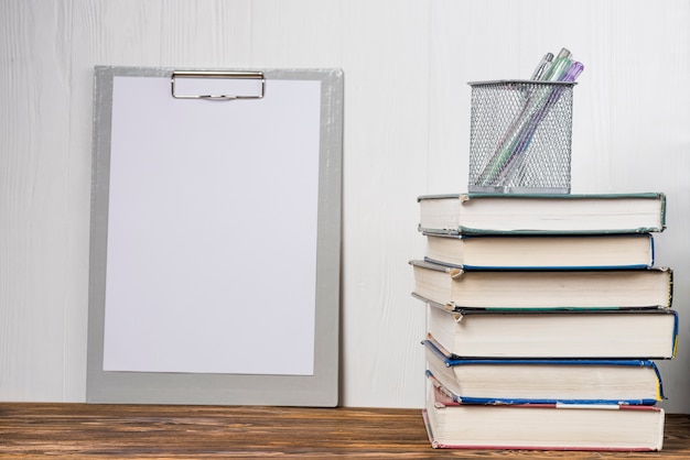 Books and stationery near clipboard