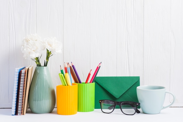 Books; vase; placeholder; envelope; eyeglasses and ceramics cup against wooden backdrop