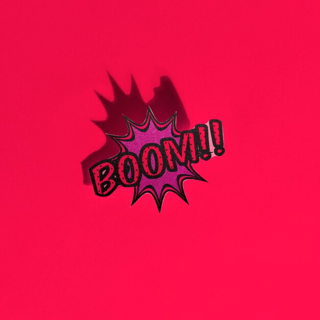 Boom comic text speech bubble pop art style sound effect on red backdrop