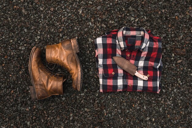 Boots near shirt and knife