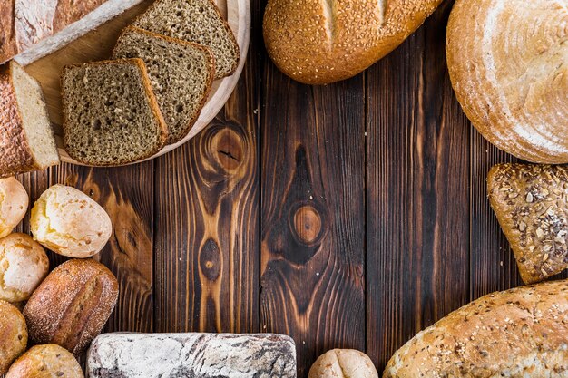 Граница различных выпеченных хлебов на деревянном фоне