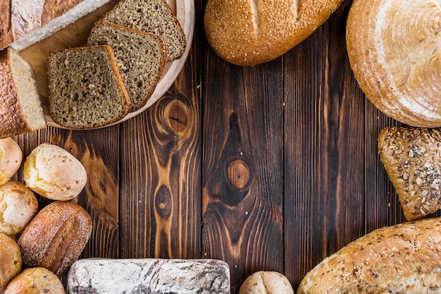 Граница различных выпеченных хлебов на деревянном фоне