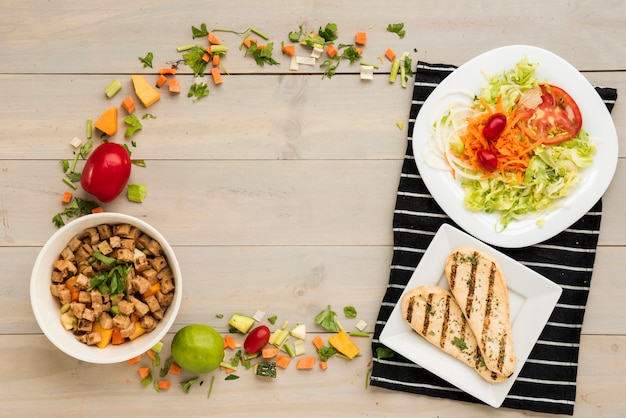 Foto gratuita confine fatto di cibo sano pronto pasto e pezzi di verdura