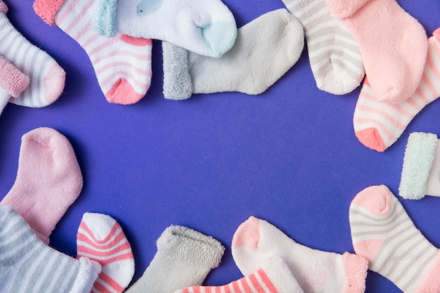Free photo border made with many baby's socks on blue background