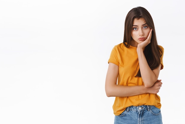 Bored cute girl sitting home alone while friends celebrating halloween woman place head on hand and look sad camera waiting for black friday sale dreaming about new shoes white background